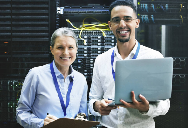 Teamwork makes technology work. Shot of two technicians working together in a server room. - Foto, immagini