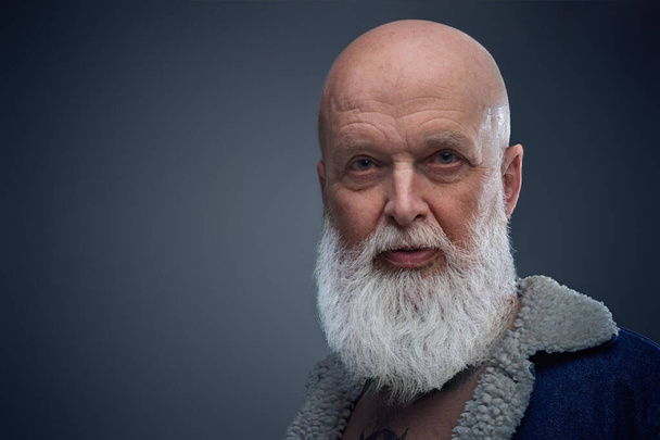 Bald elderly man with long gray beard against gray background - Foto, Imagem