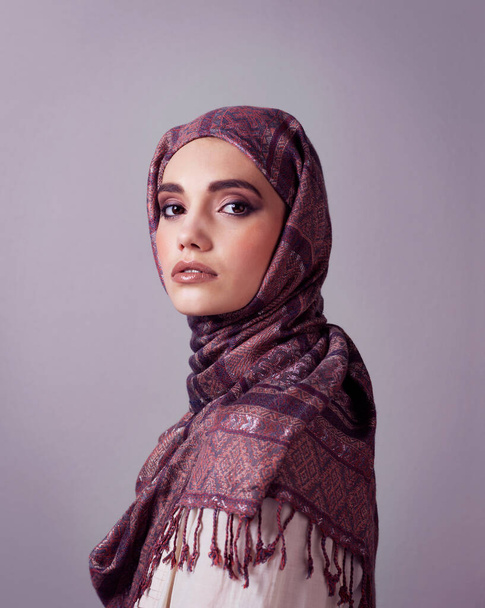 Sii sempre bella come te stessa. Studio ritratto di una giovane donna allegra che indossa un foulard colorato mentre posa su uno sfondo grigio. - Foto, immagini