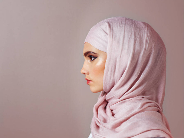 She keeps her eyes on the prize. Studio shot of a confident young woman wearing a colorful head scarf while posing against a grey background. - Foto, Bild