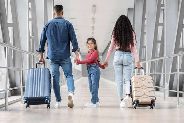 Linda niña caminando con los padres juntos en la terminal del aeropuerto - Foto, imagen
