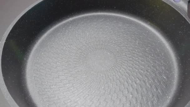 New clean frying pan. Action. Close-up of coating of modern frying pan. New model of frying pan with coating and stylish design - Footage, Video