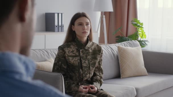 Después de la guerra recuperación psicológica. Joven mujer deprimida soldado en camuflaje hablando con el hombre psicólogo, espacio libre - Metraje, vídeo