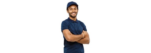 Delivery Concept - Handsome African American delivery man crossed arms over isolated on Grey studio Background. Copy Space. - Photo, Image