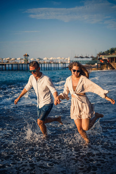 romanttinen nuori pari rakastunut yhdessä hiekalla kävelee pitkin rantaa Välimerellä. Kesäloma lämpimässä maassa. - Valokuva, kuva