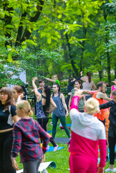 Lwów, Ukraina - 2 lipca 2021: wiele osób w parku miejskim uprawia jogę z bliska - Zdjęcie, obraz