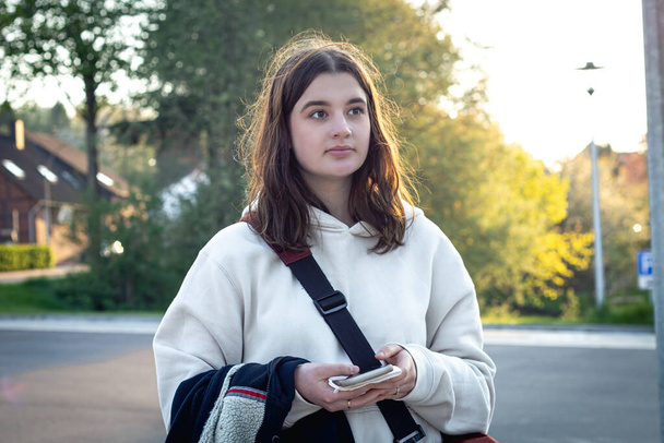 Portrait of a young woman early in the morning at a bus stop. - Photo, Image