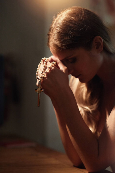 Felülről kér tanácsot. Vágott kép egy fiatal nőről, aki egy templomban imádkozik.. - Fotó, kép