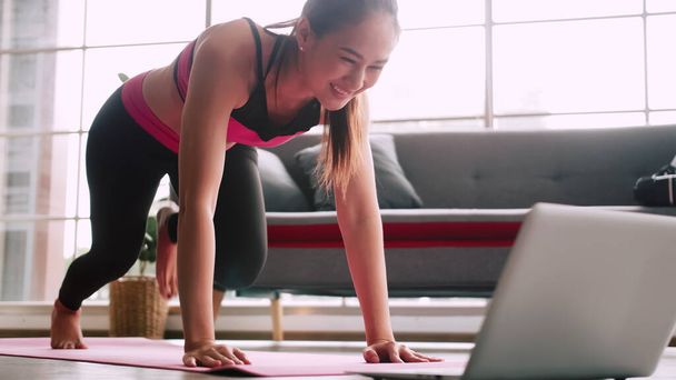 Asian girl is practicing online fitness from home. - Φωτογραφία, εικόνα