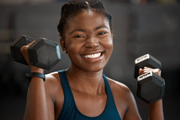 Im happiest when Im lifting. Cropped portrait of an attractive and athletic young woman working out with dumbbells in the gym. - Fotoğraf, Görsel