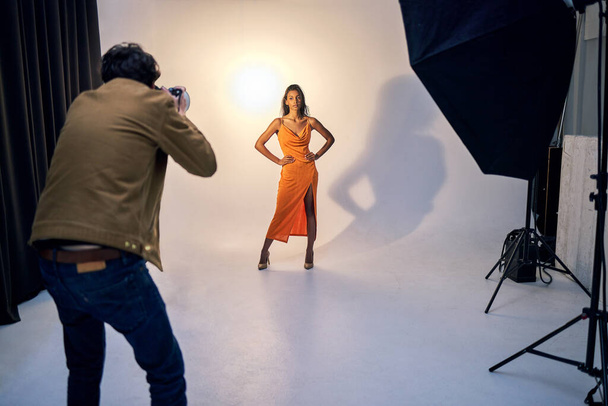 Now strike a pose. Shot of a photographer taking photos of a model in a studio. - Fotoğraf, Görsel