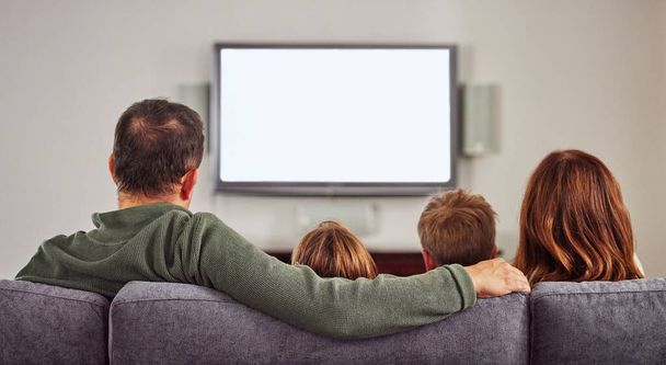 Perjantaisin on elokuvailta perheen kanssa. Laukaus tunnistamaton perhe istuu sohvalla kotona yhdessä ja liimaus katsellessaan televisiota. - Valokuva, kuva