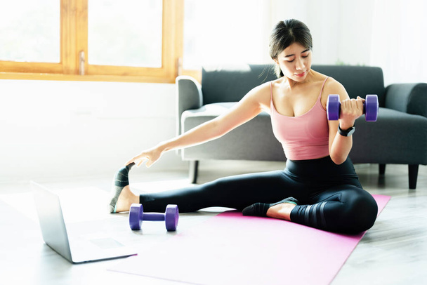 stress relief, muscle relaxation, breathing exercises, exercise, meditation, portrait of Young Asian woman relaxing her body from office work by practicing yoga by watching online tutorials. - Foto, Imagen