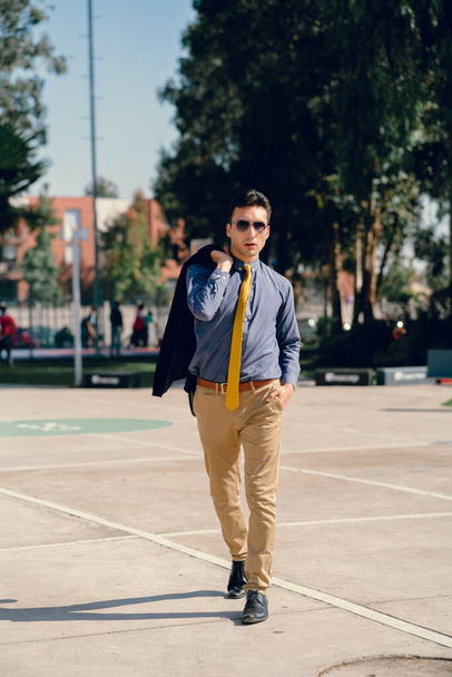 Homem com jeans de duas cores, preto e branco, gravata e óculos. - Foto, Imagem