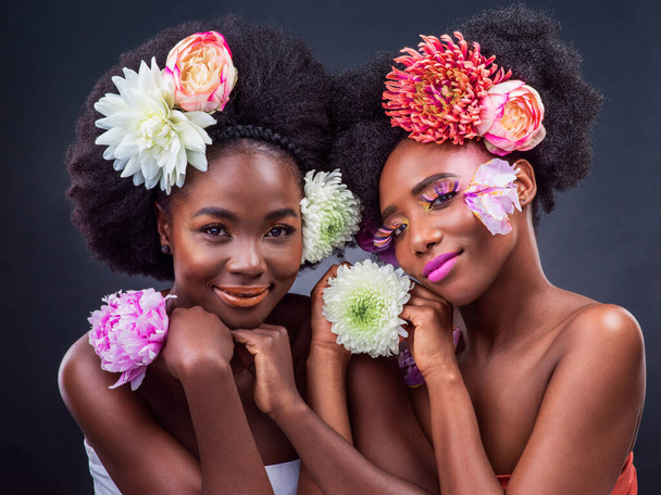 Were blossoming into the women weve always wanted to be. Cropped shot of two beautiful women posing together with flowers in their hair. - Фото, изображение