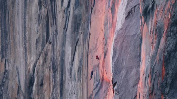 Mountain climber hanging on rope on El Capitan mountain in cinematic sunset 6K - Filmati, video