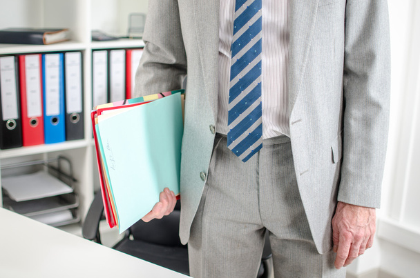 Businessman with folders under his arm - Фото, изображение