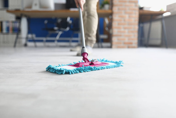Person wiping floor with fluffy mop, domestic work, housewife cleaning at home - 写真・画像
