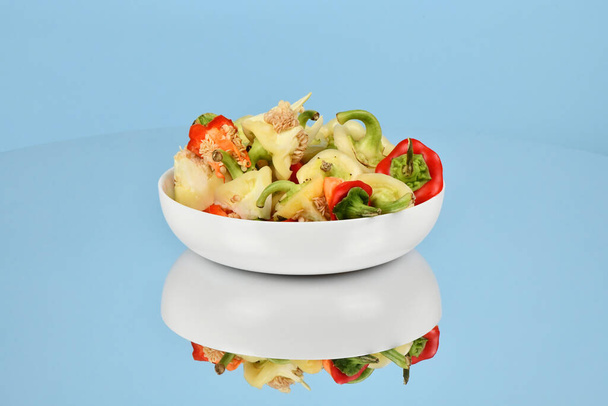 Bowl with fresh choped paprika, Bell Pepper, isolated on blue background. High resolution photo. Full depth of field. - Valokuva, kuva