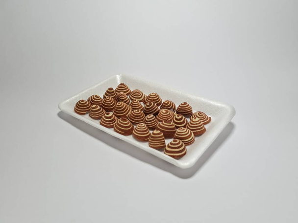 Snacks típicos de Indonesia en marrón con rayas blancas con el nombre Kuping Gajah Mini - Foto, Imagen