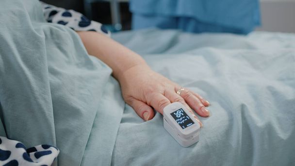 Detailní záběr oximetru na ruce staršího pacienta ležícího v posteli - Fotografie, Obrázek