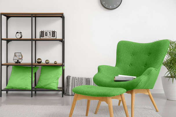 Stylowy, zielony fotel, otomana i półka we wnętrzu salonu - Zdjęcie, obraz
