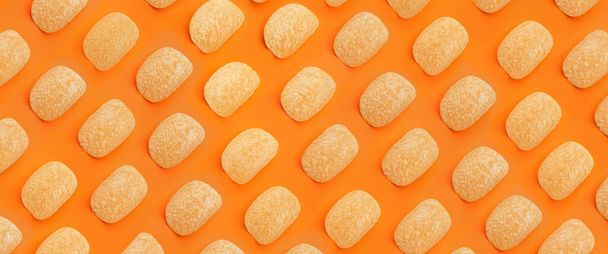 Вкусные картофельные чипсы на оранжевом фоне. Текстура для дизайна - Фото, изображение