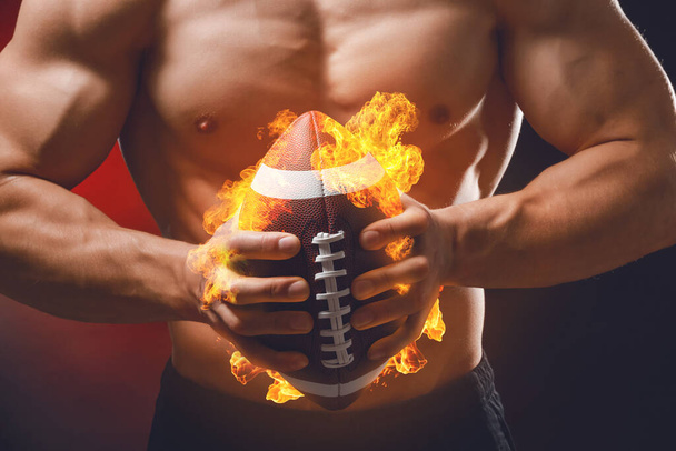 Hombre musculoso con bola de rugby ardiente sobre fondo oscuro, primer plano - Foto, imagen