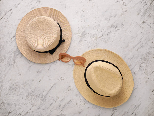 Diferentes sombreros y gafas de sol sobre fondo claro - Foto, imagen