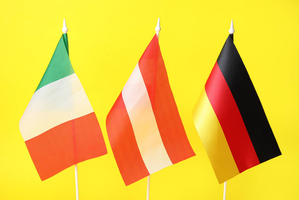 Italian, Itävallan ja Saksan liput keltaisella pohjalla, lähikuva - Valokuva, kuva