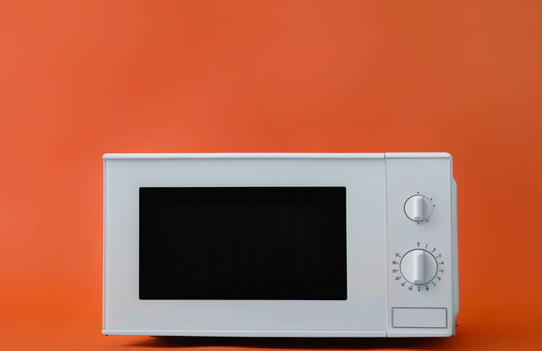 Moderno horno de microondas sobre fondo de color - Foto, imagen