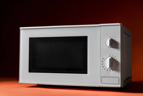 White microwave oven on color background - 写真・画像