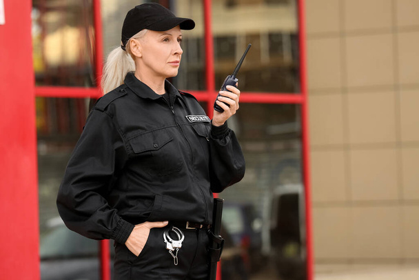 Kobieta ochroniarz z nadajnikiem radiowym na zewnątrz - Zdjęcie, obraz