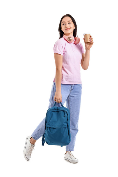 Portret van een mooie studente met kopje koffie en rugzak op witte achtergrond - Foto, afbeelding