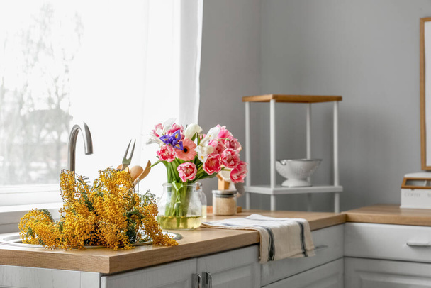 Beautiful blooming flowers in sink counter near window - Photo, Image