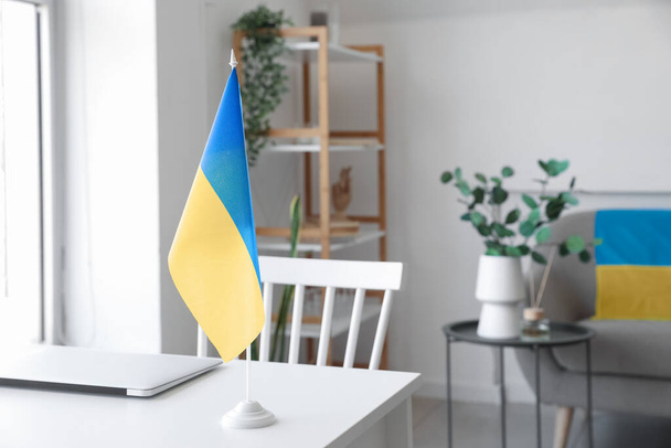 Flag of Ukraine on modern workplace in room, closeup - Valokuva, kuva