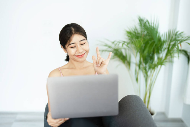 stress relief, muscle relaxation, breathing exercises, exercise, meditation, portrait of Young Asian woman relaxing her body from office work by practicing yoga by watching online tutorials. - Foto, imagen