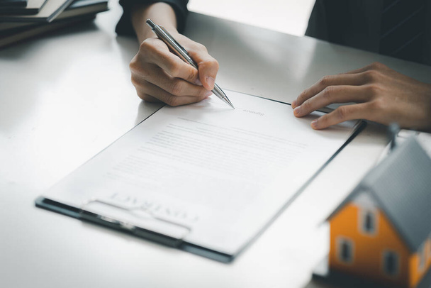 Real estate salespeople are reviewing the real estate sales contract documents before the customer agrees to sign the contract to buy the housing in the project. Real estate trading concept. - Foto, imagen