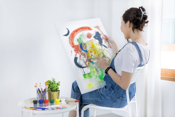 Female artist painting on canvas, Artist studio interior, Draw with watercolor, Drawing supplies , Painting and creativity, Use a brush to draw a pattern by stripes, Artwork, Using Paint Brush. - 写真・画像