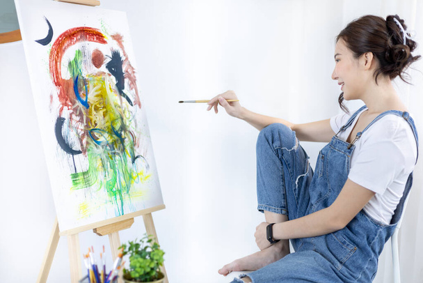 Female artist painting on canvas, Artist studio interior, Draw with watercolor, Drawing supplies , Painting and creativity, Use a brush to draw a pattern by stripes, Artwork, Using Paint Brush. - 写真・画像