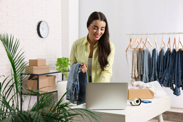 Clothes seller using laptop at workplace. Online store - Fotó, kép