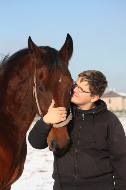 Teenager boy and bay horse portrait in winter - Foto, Imagen