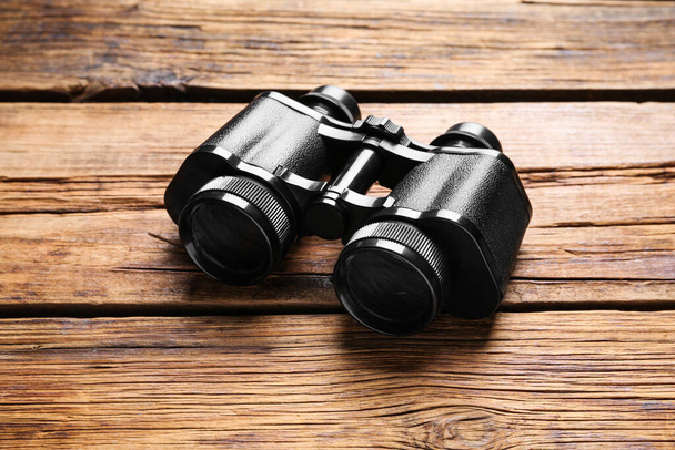 New binoculars on wooden table. Optical instrument - Foto, Imagen
