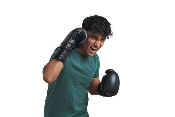 Joven boxeador peruano preparándose para lanzar un gancho, aislado. - Foto, Imagen