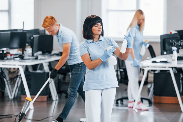 Group of workers clean modern office together at daytime. - Foto, Bild