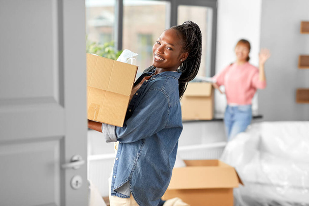 women with boxes moving to new home - Foto, Imagen