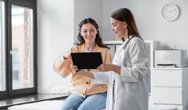 vrouwelijke arts met tablet pc en vrouw in het ziekenhuis - Foto, afbeelding
