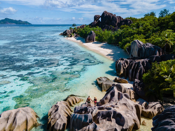 Anse Source dArgent beach, La Digue Island, Seyshelles, Drone aerial view of La Digue Seychelles bird eye view, couple men and woman walking at the beach during sunset at a luxury vacation - Фото, зображення