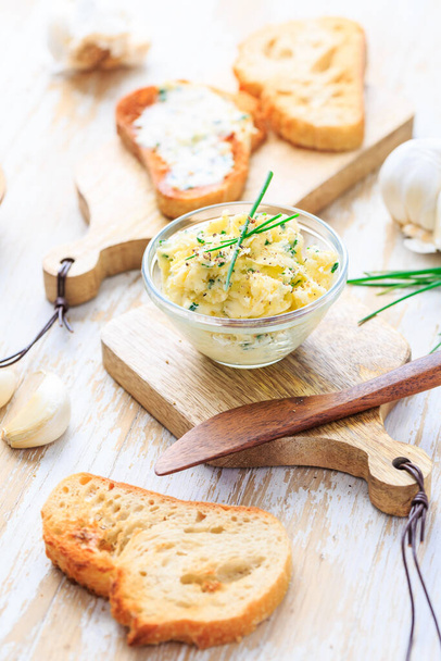 Homemade garlic butter with herbs and chives and fresh roasted baguette with salt - Foto, Imagem