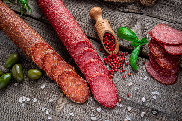 Najwyższej jakości włoskie salami na starym drewnianym stole. Salami. Suszona organiczna kiełbasa salami lub chorizo hiszpańskie - Zdjęcie, obraz